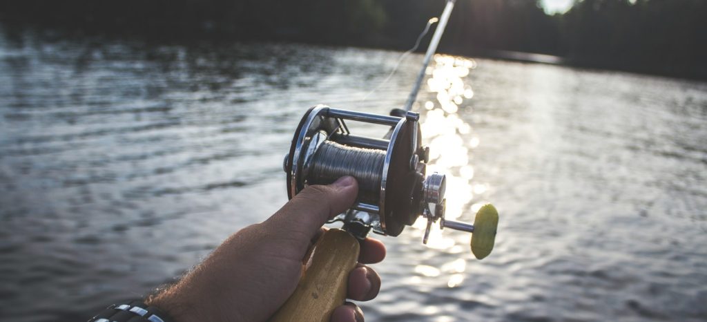 person holding black and silver fishing reel